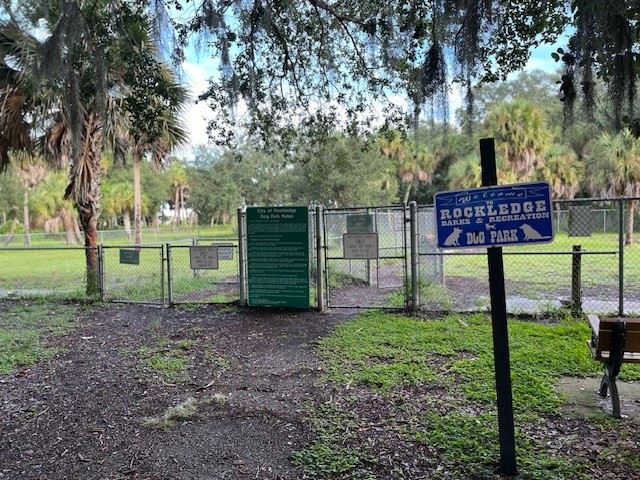 Dog park sign with park in background