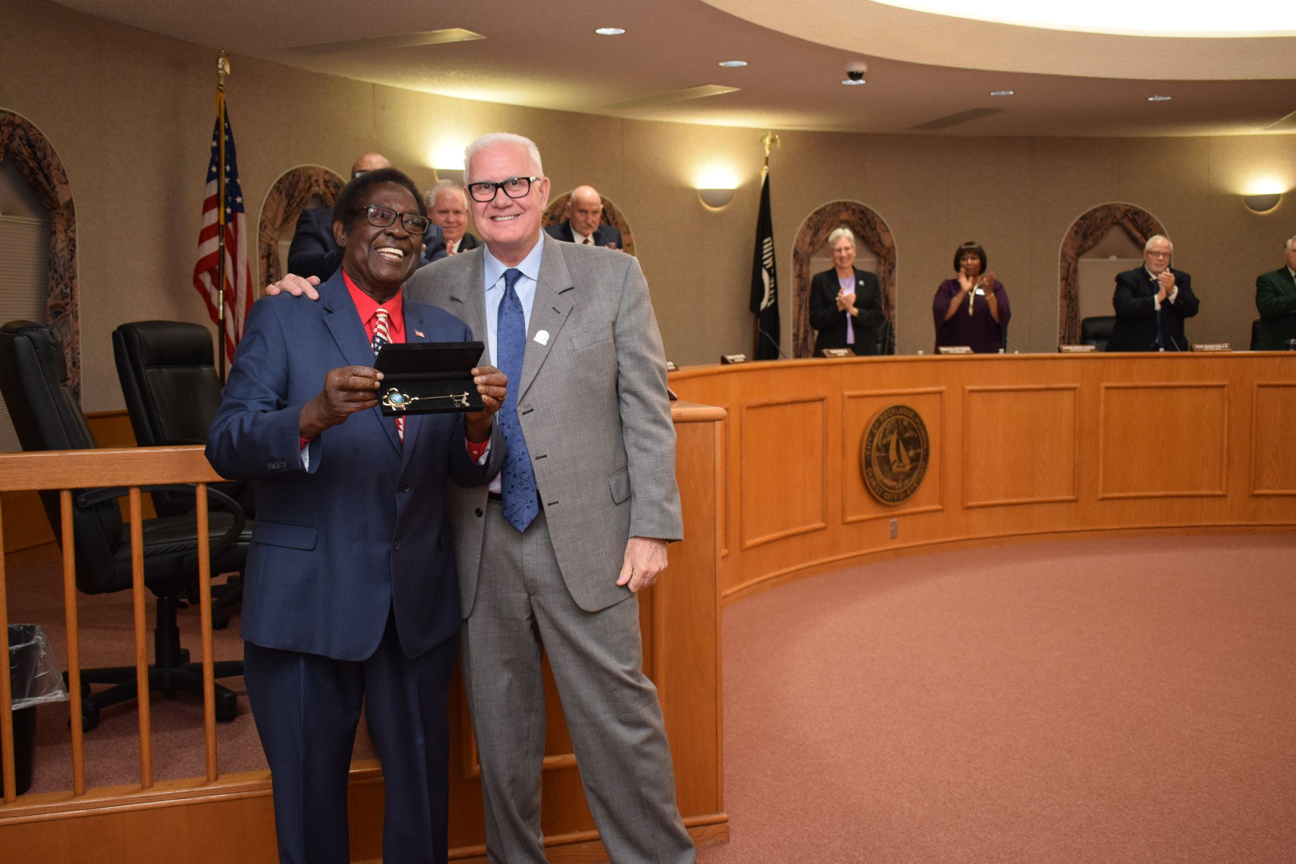 Dr. Smith receiving a Key to the City from Mayor Price with Council applauding in background